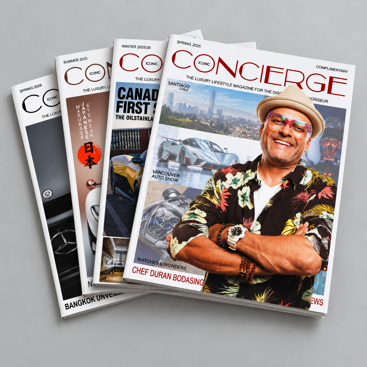 Four issues of Iconic Concierge magazine stacked together, with Chef Duran Bodasing on the top cover.